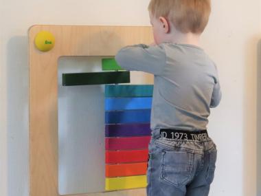 Dagplejebarn leger med legeværktøj på væggen